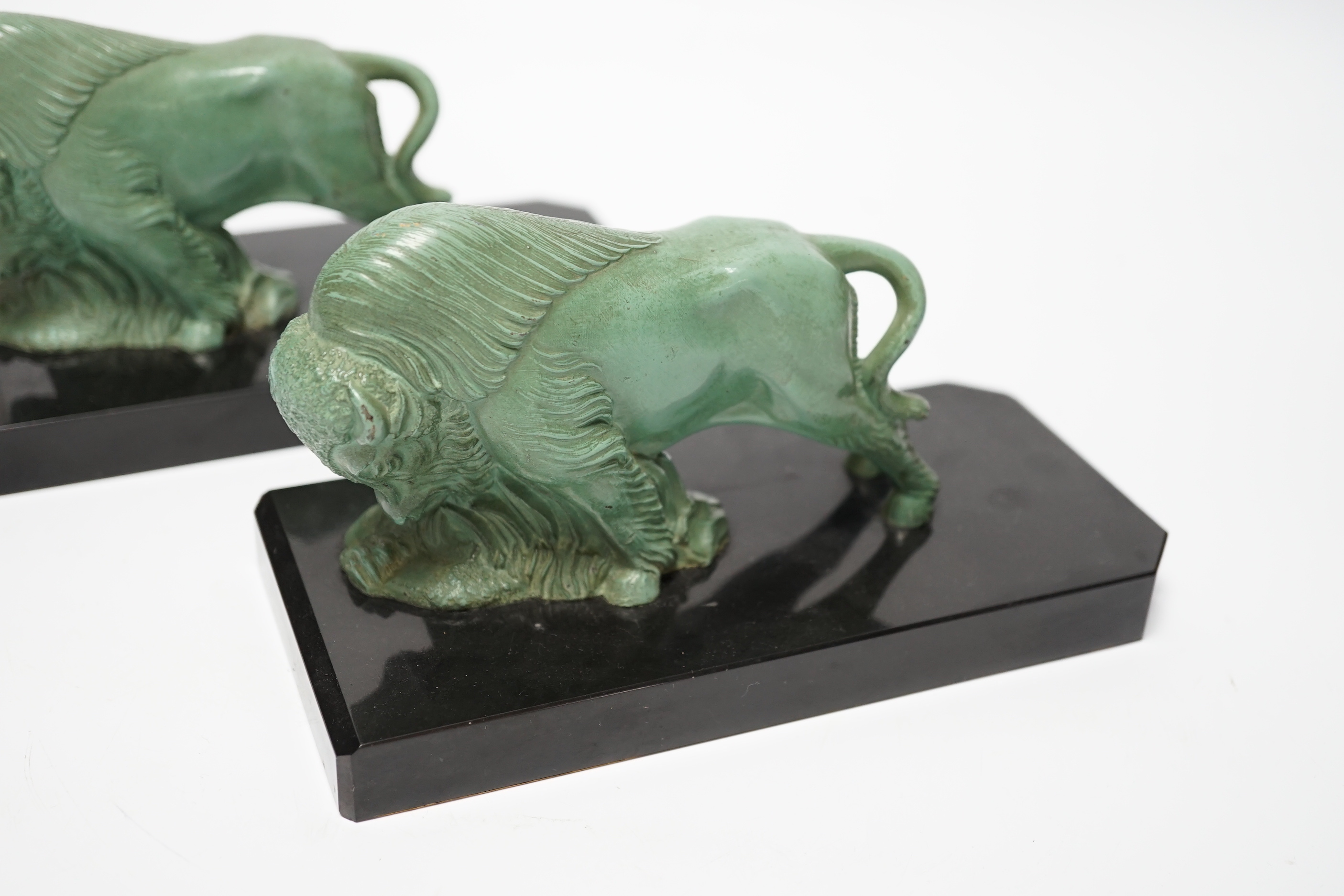 A pair of early 20th century green patinated spelter ‘bison’ book-ends, 19cm long